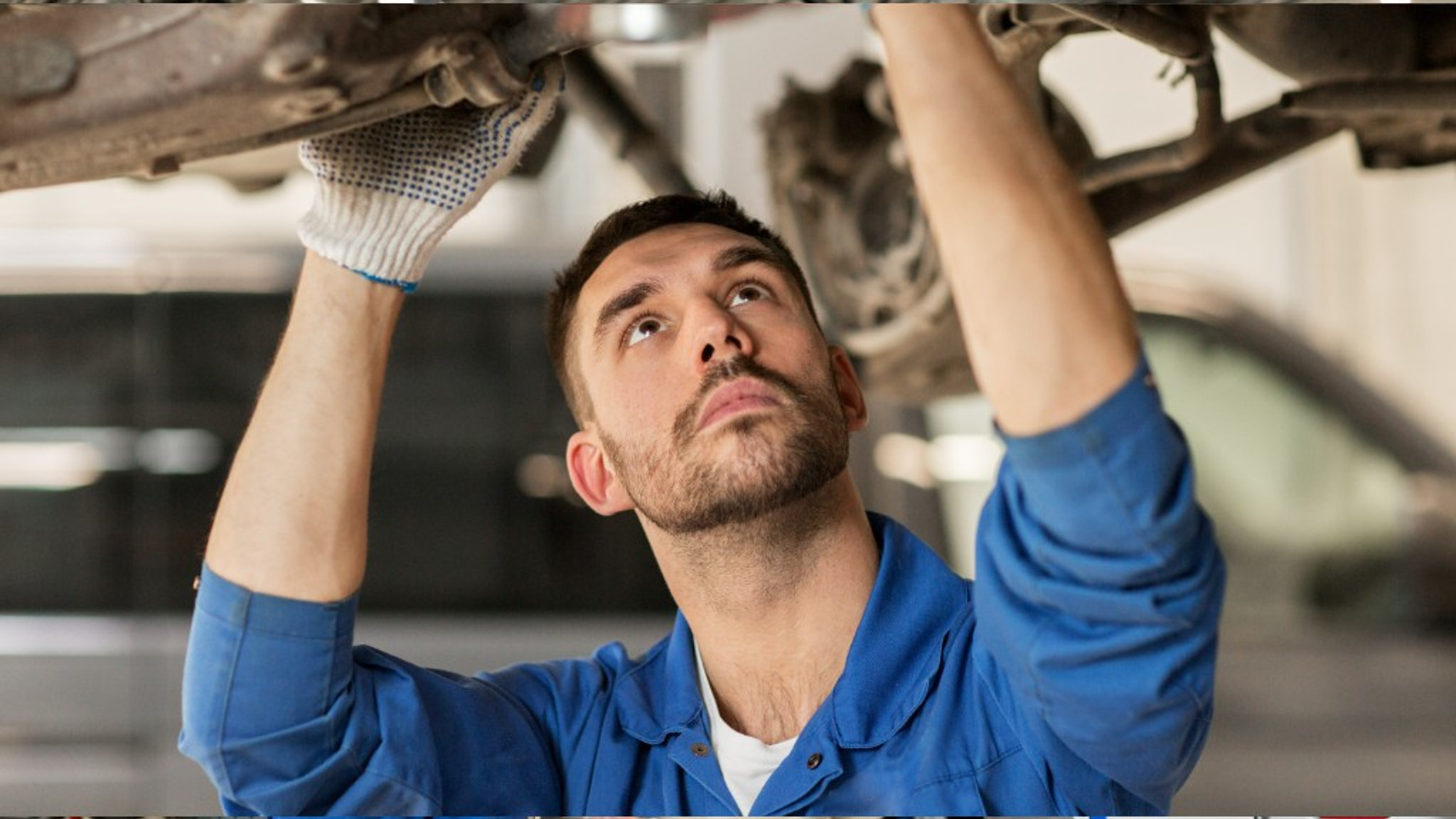 Mechanic inspecting a vehicle on a lift during diagnostic work
